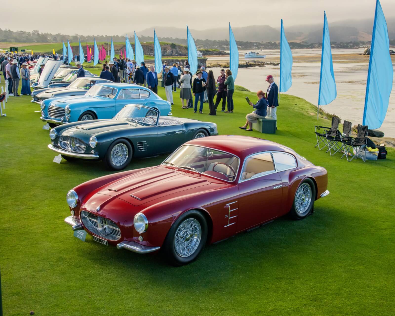 Maseratis lined up at the water's edge on the 18th fairwway